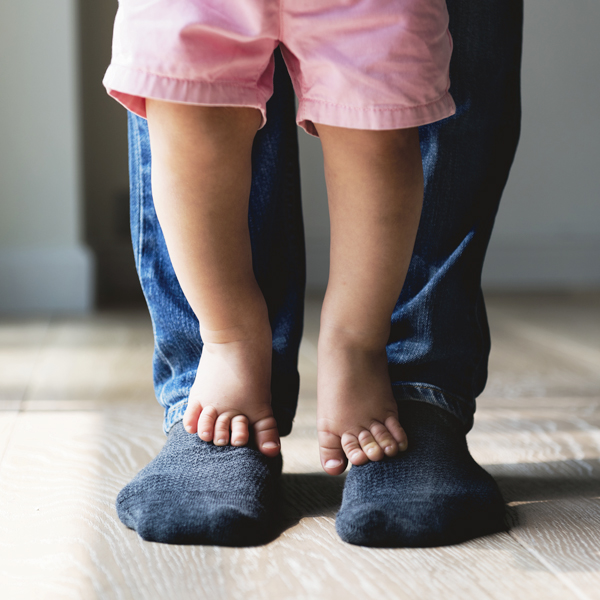 Parent with foster child standing on feet