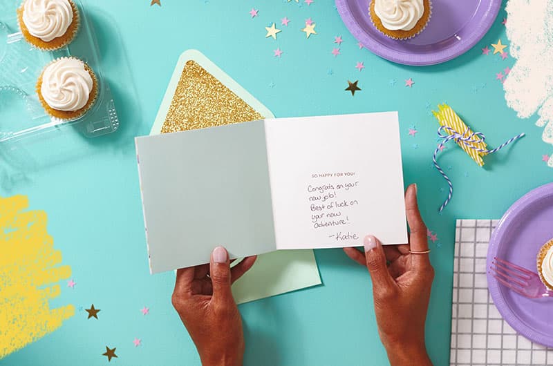 Hands holding a greeting card with handwritten message inside that reads, 