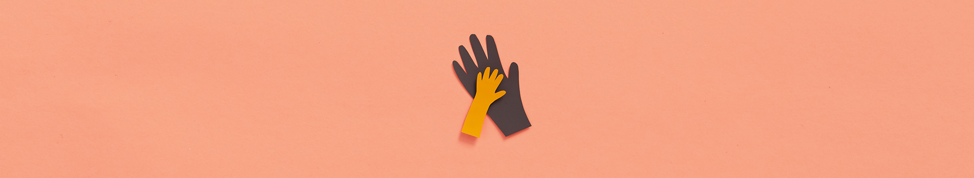 Large and small paper cut hand shapes overlapping on a peach colored background