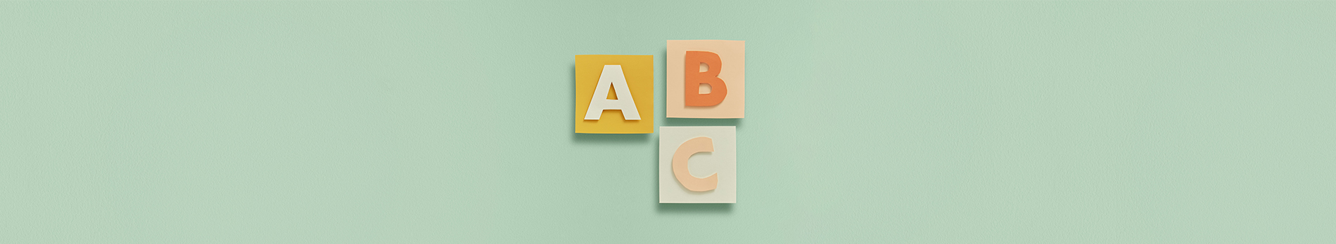 Paper cut alphabet blocks on a light green background