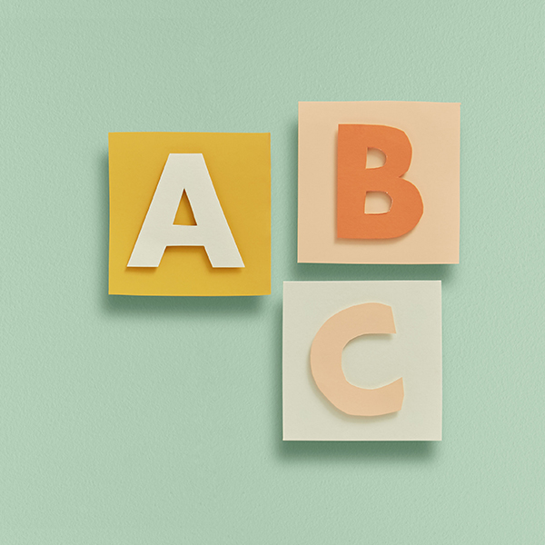Paper cut alphabet blocks on a light green background