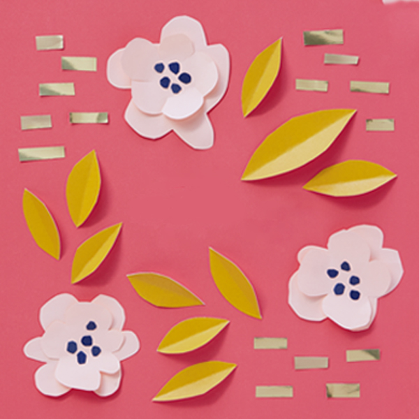Paper cut spring flowers and leaves on a dark pink surface