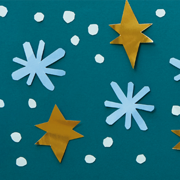 Paper cut snowflake and star shapes on a dark green surface
