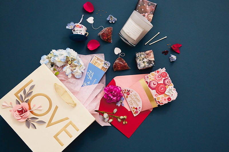 A Valentine's Day care package for a romantic date night, including a candle, matches, tea and a card.