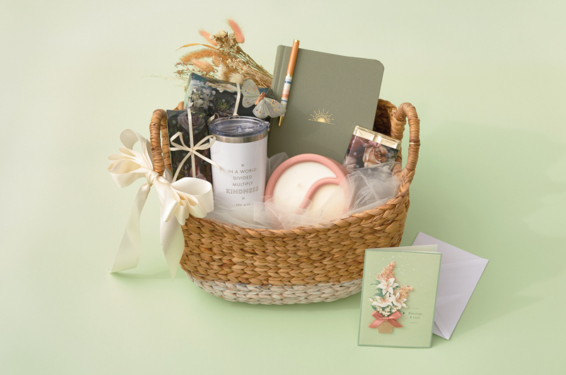 A self-care themed Easter care package with a journal and pen, scented candle, travel tumbler and greeting card.