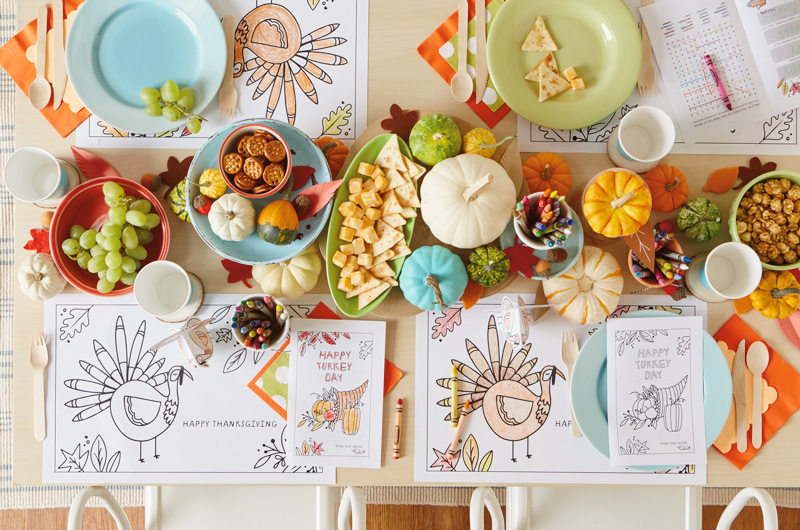 Kids' Thanksgiving table settings with coloring placemats, activity books and place cards.