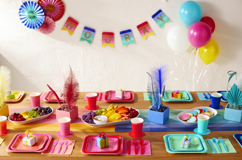 A rainbow-colored party spread featuring Color Pop party products in several colors.