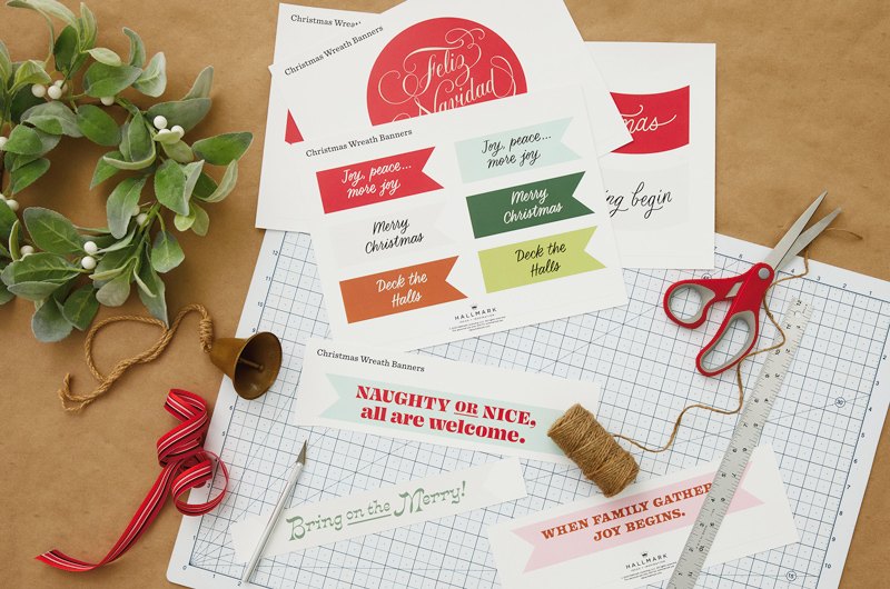Supplies needed to make a personalized wreath include our free printable banners, scissors or craft knife and ruler, ribbon or twine, and a wreath.