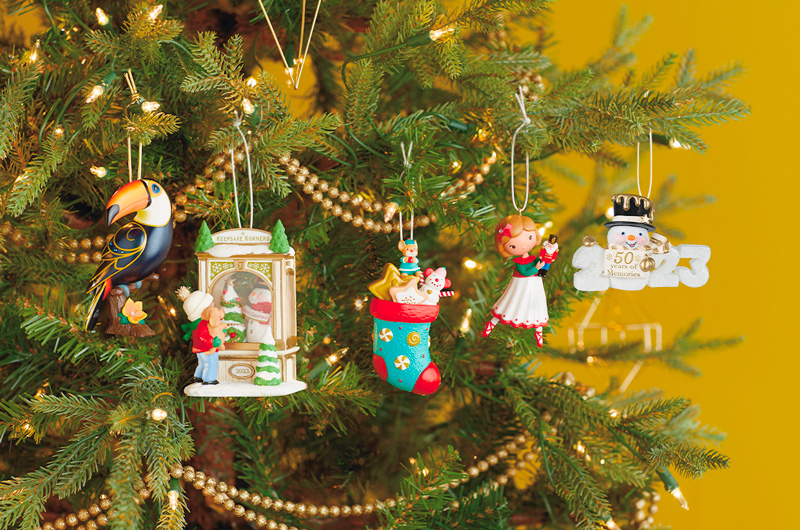 A group of five 50th Anniversary Keepsake Ornaments hanging on a Christmas tree.
