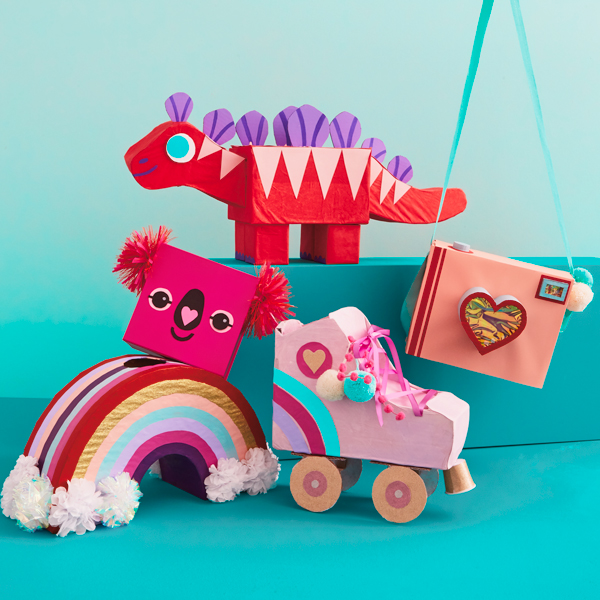 A group of valentine boxes in the shape of fun objects, including a camera, a roller skate, a rainbow, a koala and a dinosaur.