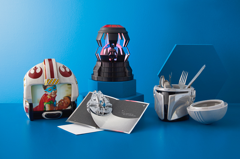 Any of these Star Wars gifts would be great for a parent who's a fan of the franchise: A Rebel Alliance helmet-shaped frame; a Darth Vader Chamber water globe, a Boba Fett shaped utensil caddy and a pop-up card featuring the Millennium Falcon.