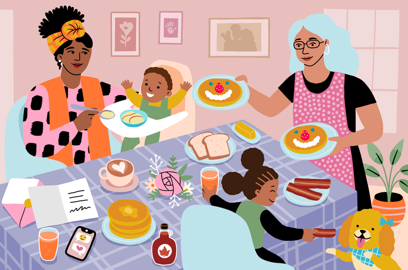 An illustration of two moms at a Mother's Day breakfast table; one is feeding a toddler in a high chair, the other is passing a plate of pancakes to their little girl, who is feeding a piece of bacon to the family dog.