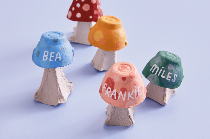 Placeholders in the shape of mushrooms, made from paper pulp egg cartons and painted with craft paint.
