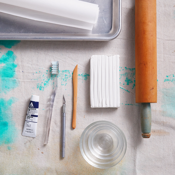 Materials to make DIY clay bowls, including acrylic paint, over-bake clay and more.