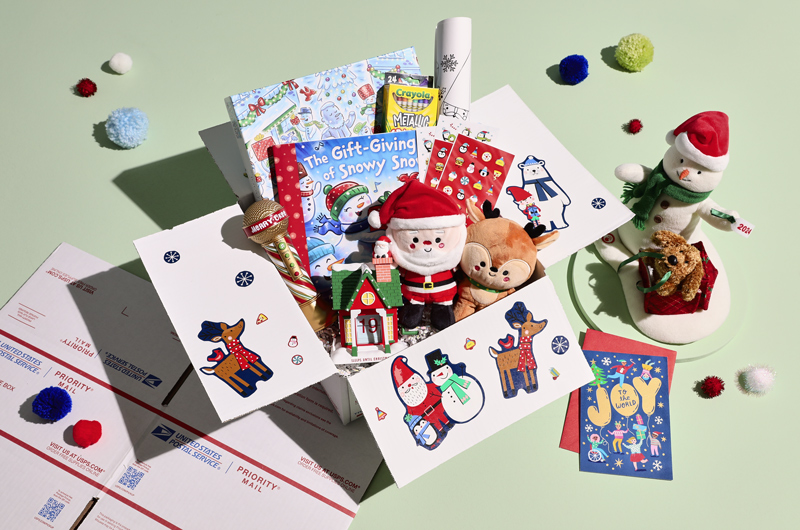 A Christmas care package for kids that includes a Christmas countdown figurine, a Santa and Rudolph Better Together magnetic plush pair, an interactive, dancing Snowman plush and coordinating book, crayons and free coloring pages, a voice enhancing 