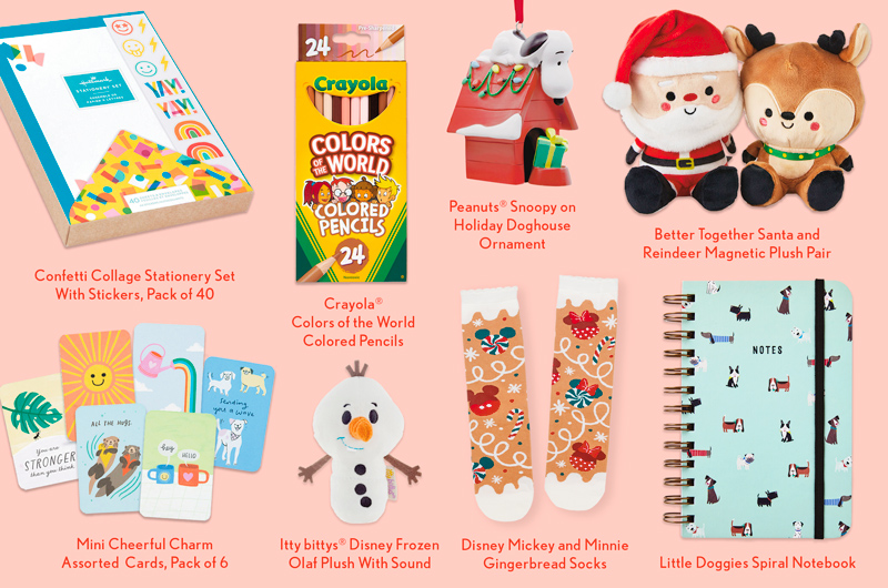 A collection of stocking stuffer ideas for kids, including a confetti-themed stationery set, a set of Crayola Colors of the World colored pencils, a Peanuts Snoopy on holiday doghouse Christmas ornament, a Better Together Santa and Reindeer magnetic plush pair, a spiral-bound notebook covered in little dog illustrations, a pair of socks with a Disney gingerbread pattern, a miniature plush version of Olaf from Disney Frozen, and a 6-pack of mini greeting cards.