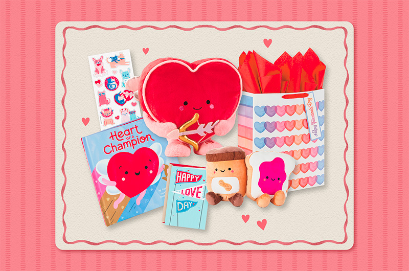 A selection of Valentine's Day gift ideas for kids, including an interactive plush heart wearing Cupid wings and holding Cupid's bow and arrow, along with a coordinating book entitled, 