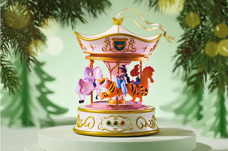 A Keepsake Ornament featuring Disney Princesses Cinderella, Jasmine and Ariel, riding on a carousel.