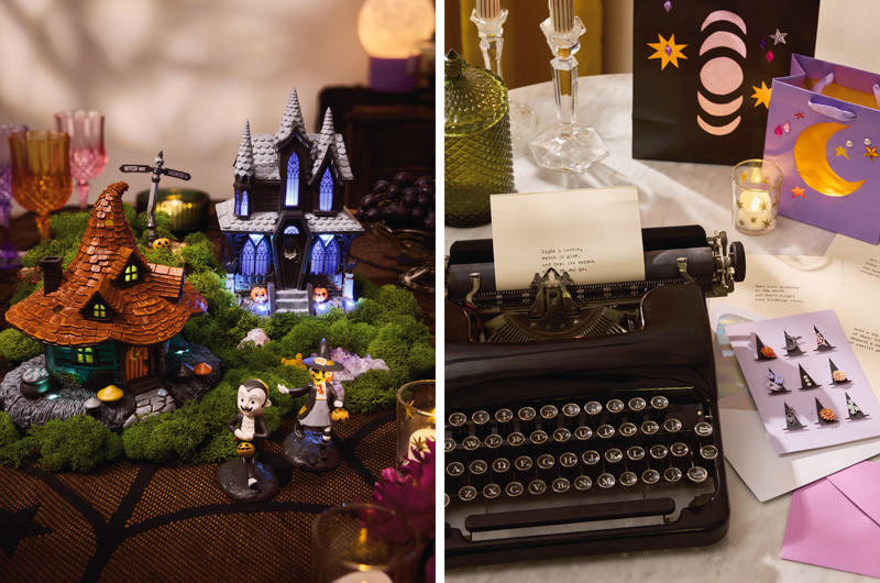 Two pieces of Halloween tabletop decor with light and sound, including a witch house and a haunted house, sit at the center of a table decorated for a witch-themed Halloween party; next to this is a setup for a 