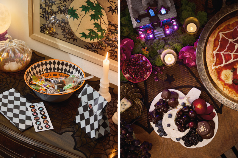 Two images showing witchy Halloween party decor setup ideas; at left is a treat bowl on a sideboard table, with a mixture of candy in it and treat bags for take-home bags lying nearby; at right is a serving tray made of white marble and shaped like a pumpkin, covered in fresh fruit and chocolate; nearby this fruit try is a pizza with a spiderweb design piped onto the top, and a haunted house figurine that's lit up from within.