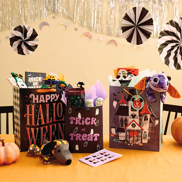 A collection of Halloween boo bag ideas that include a Peanuts-themed boo bag, a Disney-fan boo bag featuring Mickey and Stitch, and a Haunted Mansion-themed boo bag.