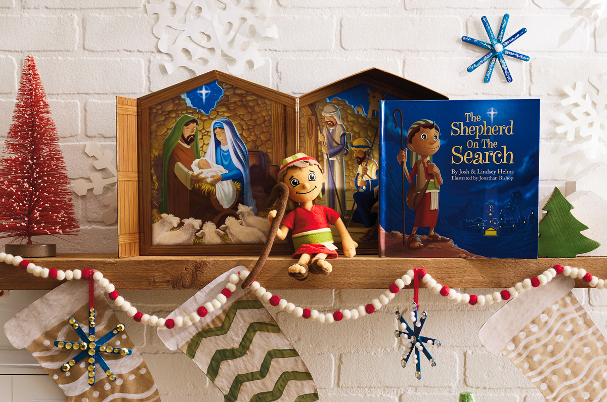 A plush shepherd doll sits on a mantel next to a book titled, 