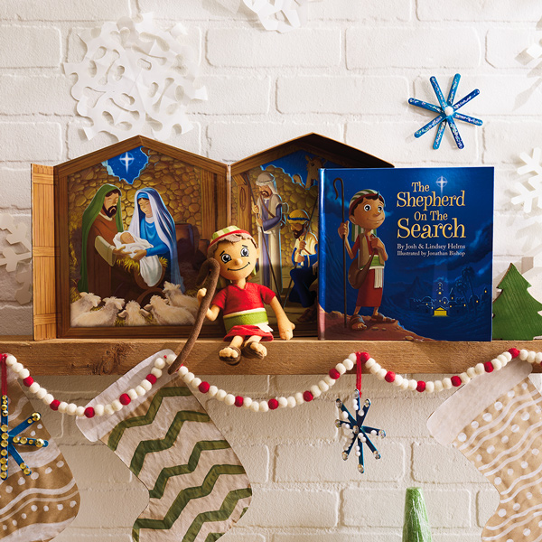 A plush shepherd doll sits on a mantel next to a book titled, 