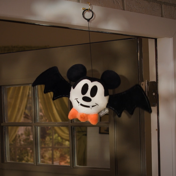 A plush Vampire Bat Mickey Mouse hangs in a doorway, waiting to drop down and surprise a trick-or-treater.