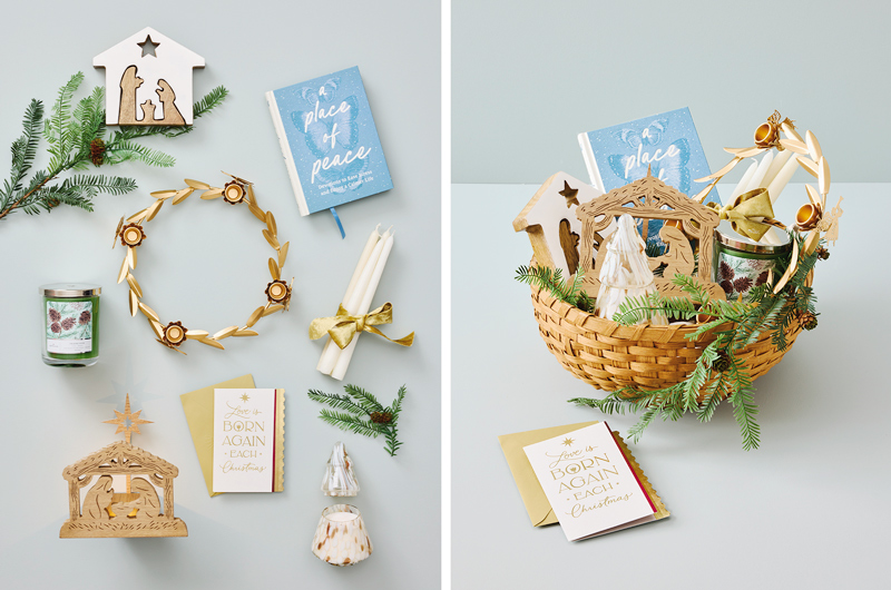Faith-inspired Christmas gift basket with a nativity scene, devotional books, candles, evergreen sprigs, a decorative wreath, and holiday keepsakes displayed in a woven basket on a soft blue background.