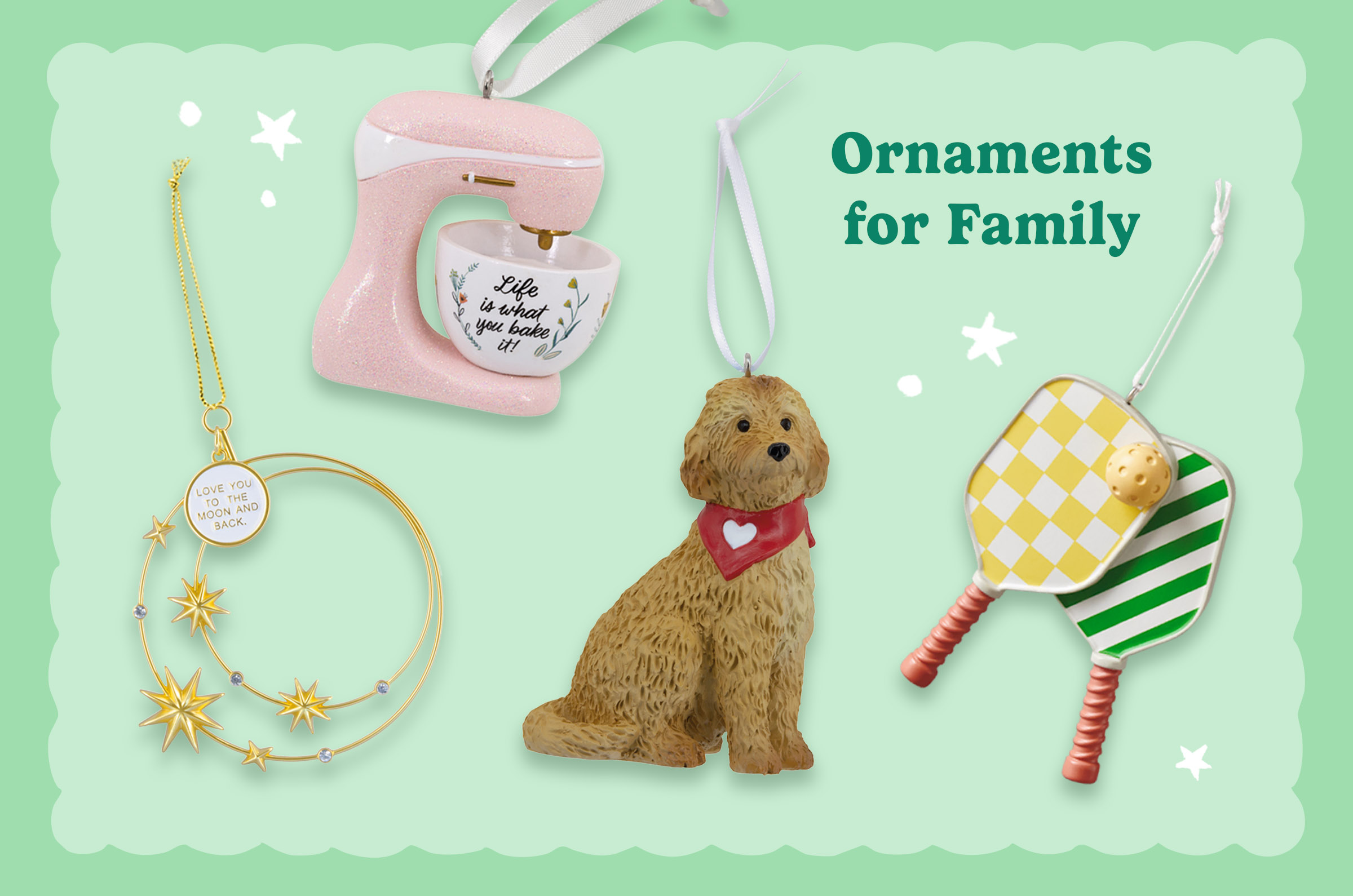 Collection of family-themed Christmas ornaments including a pink stand mixer with a baking bowl, a gold “Love You to the Moon and Back” celestial ornament, a dog wearing a heart bandana, and a pickleball paddle ornament on a mint-green background with the heading “Ornaments for Family.”