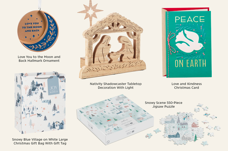 Collection of Winter Wonders holiday gifts and décor including a moon-and-stars ornament, illuminated nativity tabletop decoration, peace-themed Christmas card, snowy village gift bag, and a winter scene jigsaw puzzle.