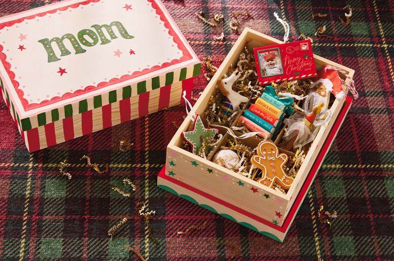 A wooden box that's been painted with candy cane stripes and stars in shades of red and green; the box lid has been hand painted with 