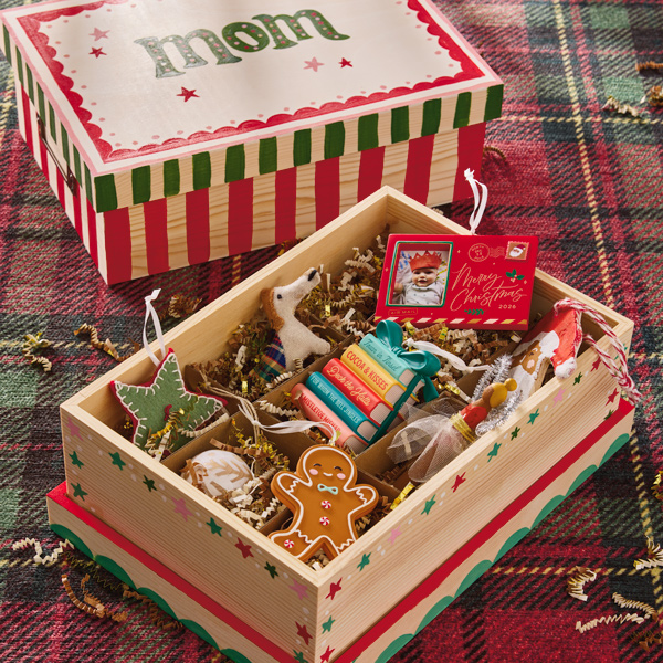 A wooden box that's been painted with candy cane stripes and stars in shades of red and green; the box lid has been hand painted with 